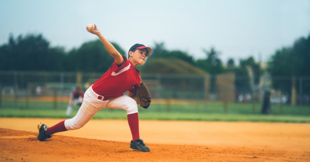 Photo of a young athlete pitcher, throwing a baseball.