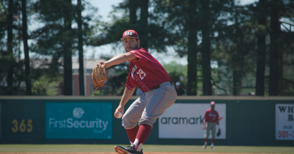 Baseball pitcher mid-throw on the mound, showcasing overhead throwing mechanics used in the blog about injury prevention for overhead athletes.