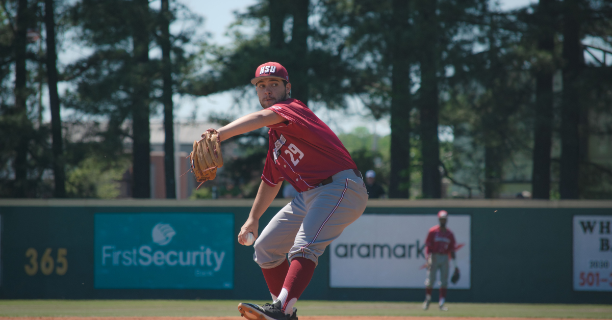 Baseball pitcher mid-throw on the mound, showcasing overhead throwing mechanics used in the blog about injury prevention for overhead athletes.