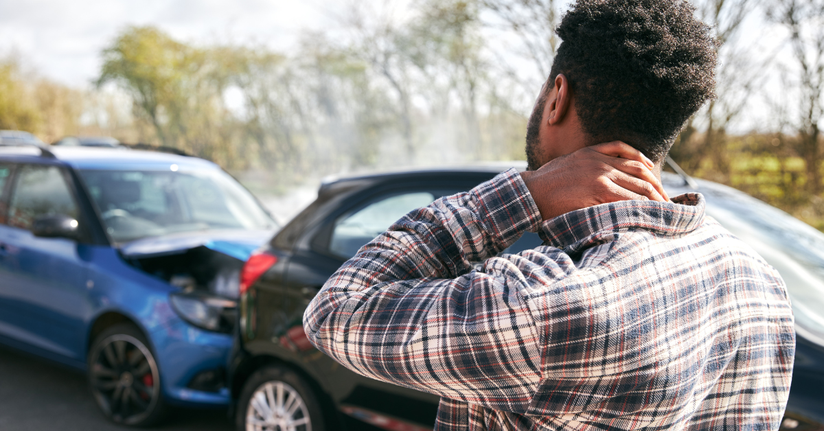 Photo of a man holding his neck after a car accident
