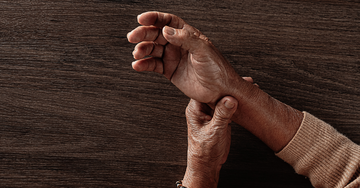 photo of a person holding their hand in pain with osteoporosis.